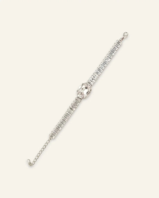 Midnight Luxe Bracelet, a silver-tone crystal line bracelet featuring a large central crystal oval gemstone flanked by rows of rectangular-cut clear stones and an adjustable chain extension on a neutral background.