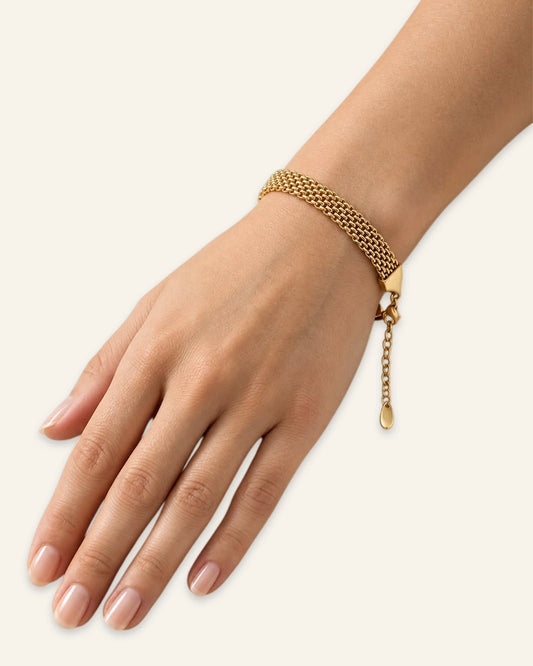 Woman wearing gold plated stainless steel Milanese mesh bracelet on wrist.