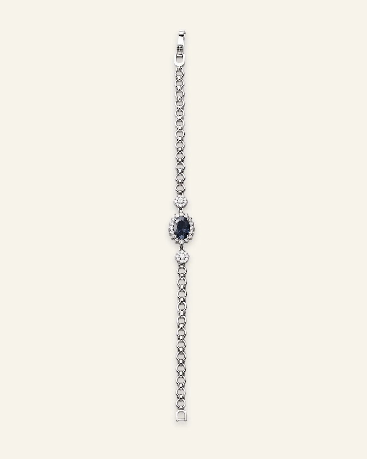 Silver-tone link bracelet featuring a central oval crystal blue stone with a pave halo and delicate crystal accents.
