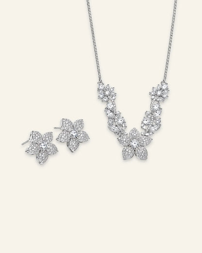 Silver floral necklace and matching flower stud earrings set featuring pave-set crystal petals and leaf vine details.