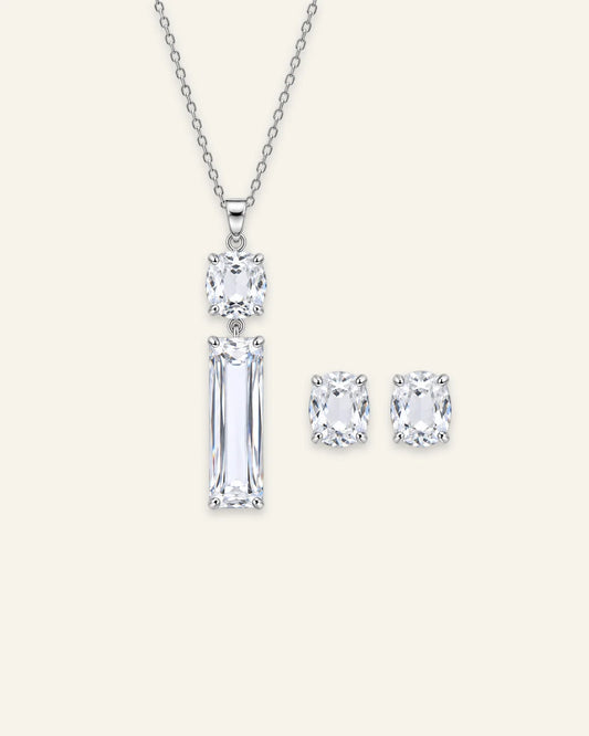 Silver drop pendant necklace and matching stud earrings jewelry set featuring a stacked cushion-cut and long rectangular emerald-cut clear gemstone.