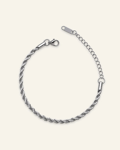 A silver-toned twisted rope chain bracelet with a lobster clasp and extension chain, displayed on a light cream background.