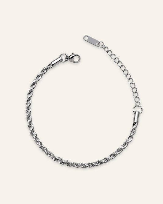 A silver-toned twisted rope chain bracelet with a lobster clasp and extension chain, displayed on a light cream background.