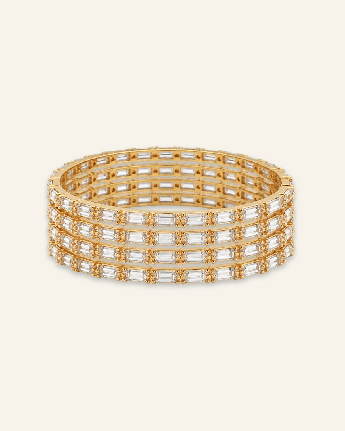 Elegant Rhinestone Bracelet, a stacked set of four gold-tone metal bangles densely set with alternating baguette-cut stones and shining stone accents against a clean neutral background.