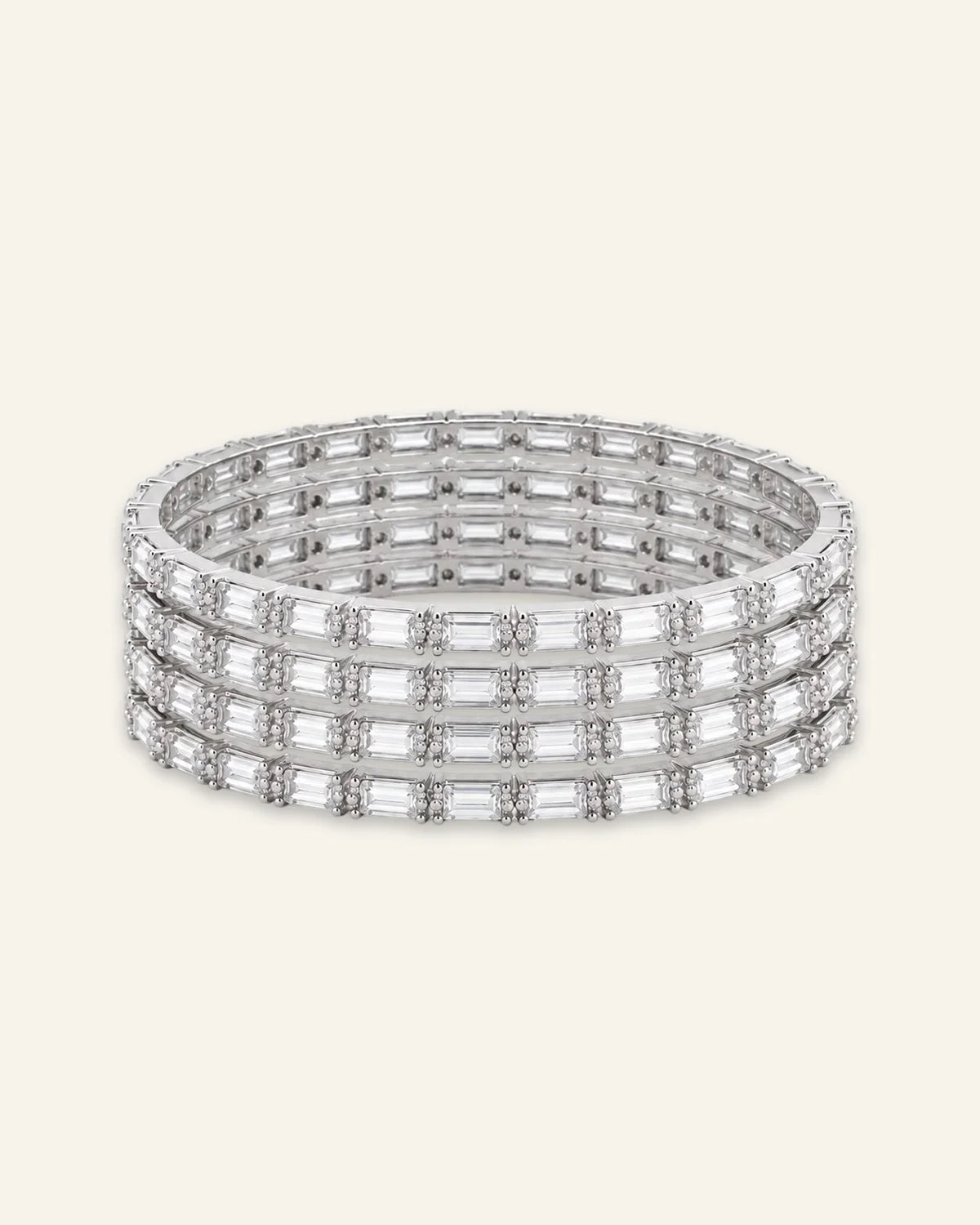 Elegant Rhinestone Bracelet, a stacked set of four silver-tone metal bangles densely set with alternating baguette-cut stones and shining stone accents against a clean neutral background.