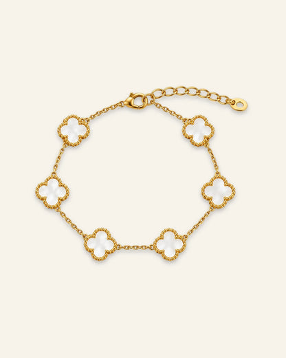 Floral Emblem Bracelet featuring white floral motifs with gold-tone detailing and a delicate chain.