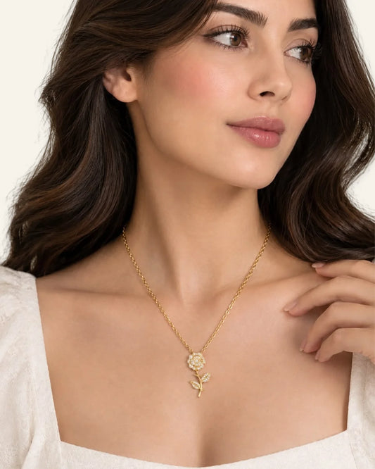 Woman wearing a luxe gold floral pendant necklace with crystal accents.