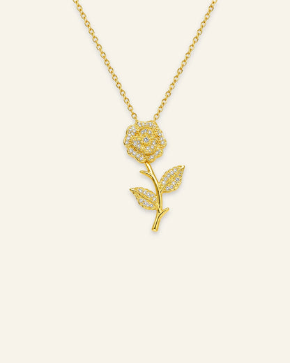 Luxe gold floral pendant necklace with pave crystal accents on a gold chain.