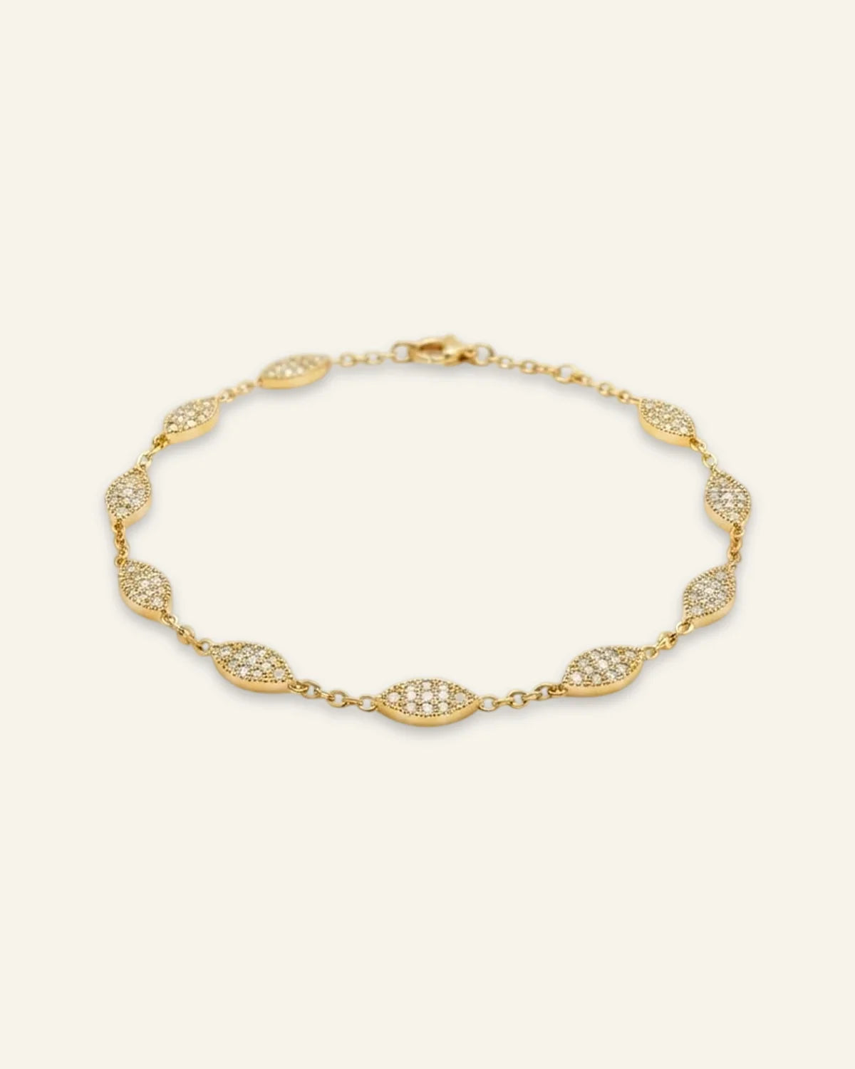 Minimalist Marquise Charm Bracelet, a delicate gold-tone chain bracelet featuring spaced marquise-shaped stations densely set with shining pave stones against a clean neutral background.