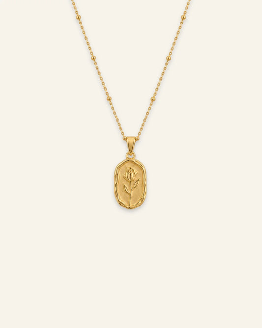 Gold Rose Muse pendant necklace featuring a textured oval pendant with an embossed rose flower motif on a beaded satellite chain.