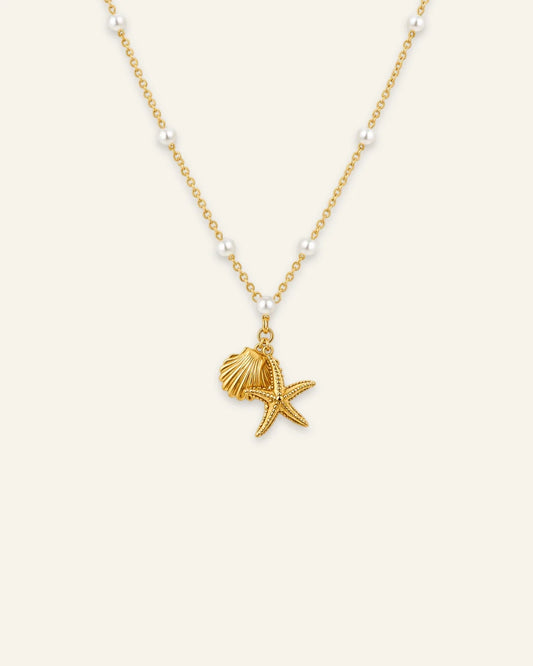 Gold link chain necklace featuring spaced pearl beads and dangling starfish and scalloped seashell charms.